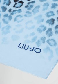 Sciarpa azzurro chiaro con un motivo a stampa leopardata in tonalità più scure. I bordi sono leggermente sfilacciati. Il logo Liu Jo appare in blu navy.
