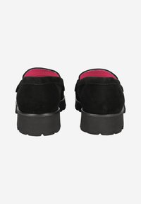 Chaussures en cuir suédé noir avec un bout arrondi, semelle en caoutchouc noir épaisse et doublure rose vif. La vue arrière montre une texture douce et un minimalisme dans les détails.