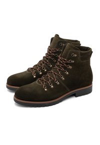 Pair of dark brown suede hiking boots with metal eyelets and brown laces, featuring thick black rubber soles and padded ankle collars.