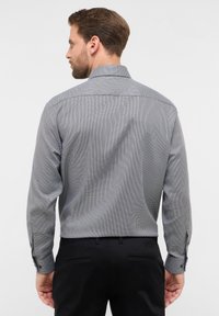 Langarmshirt in zwart-wit ruitpatroon, met een button-down kraag, textuurstof en knoopmanchetten.