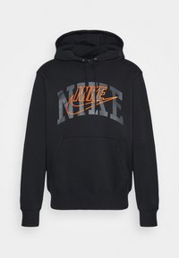 Svart huvtröja med framficka, dragsko i huvan och en framträdande orange och grå Nike-logotyp över bröstet. Mjuk tygkänsla.