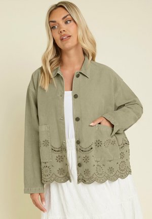 Olivgrüne Cord-Jacke mit großen Taschen und floralen Ösenverzierungen am Saum. Besitzt silberne Knöpfe und einen lässigen Schnitt.