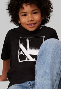 Calvin Klein Jeans MONOGRAM GRID RELAXED - Triko s potiskem - black