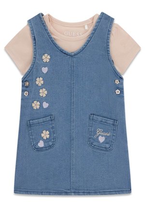 Robe salopette en denim bleu pour petite fille avec poches avant, broderies florales et en forme de cœur, superposée à un t-shirt rose clair à manches courtes.