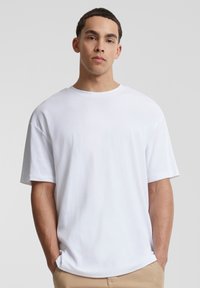 Tricou alb cu mânecă scurtă, cu o croială lejeră, gât rotund și textură fină. Fără modele sau accente vizibile. Potrivit pentru ținute casual.