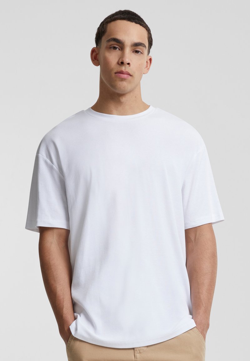 Tricou alb cu mânecă scurtă, cu o croială lejeră, gât rotund și textură fină. Fără modele sau accente vizibile. Potrivit pentru ținute casual.