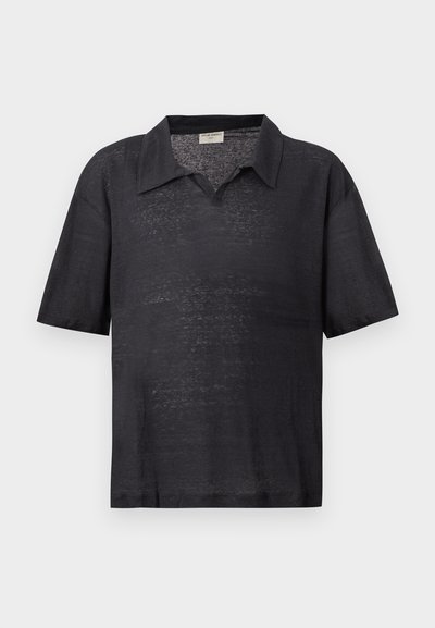 Μαύρο ελαφρύ πλεκτό πόλο με κοντά μανίκια, με διαχυμένο γιακά και χαλαρή εφαρμογή, εμφανιζόμενο σε απλό φωτεινό φόντο.