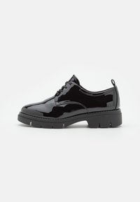 Scarpa oxford in vernice nera con punta arrotondata, design con lacci e suola in gomma nera spessa caratterizzata da un motivo a scanalature orizzontali.
