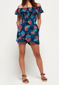 Bloemenprint playsuit met blote schouders, gerimpelde halslijn, blauwe achtergrond, groene bladeren en roze bloemen; voorzien van zijzakken.