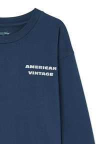 Long-sleeve navy blue cotton shirt featuring a crew neck and the text "AMERICAN VINTAGE" in bold white letters on the chest.