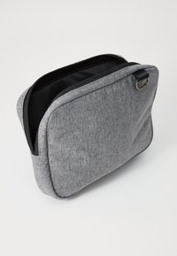 Γκρι υφασμάτινη τσάντα σε ορθογώνιο σχήμα, με φερμουάρ και μαύρο εσωτερικό. Διαθέτει μια μικρή μεταλλική λαβή στη μία πλευρά.