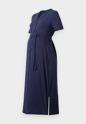 Tamsiai mėlynas, trumpomis rankovėmis nėščiosioms skirtas suknelė su mygtukų priekiu, diržu talijoje ir šonu plyšiu. Pagaminta iš minkštos, lygaus audinio.