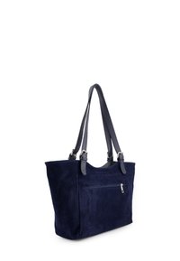 Marineblauwe suède totebag met twee donkere leren schouderbanden en een voorzak met rits. Het ontwerp heeft een zachte textuur en een gestructureerde vorm.