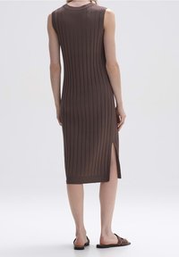 Vestido midi marrón de canalé con un diseño ajustado, sin mangas y con una abertura lateral, confeccionado en un tejido de punto texturizado. Cuello redondo simple.