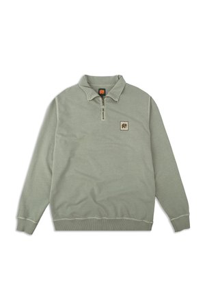 Bluza z półgolfem w stonowanej zielonej tkaninie z półzamkiem, kołnierzem, elastycznymi mankietami oraz naszywką z logo na klatce piersiowej.