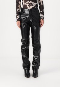 Svarta kroko-präglade fuskläderbyxor med smal passform. Har hög midja, framfickor och en glänsande yta.