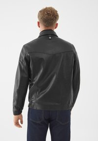 Giubbotto in pelle nera con colletto, dettagli di cucitura e una texture liscia. Presenta un bottone al collo e polsini elasticizzati.
