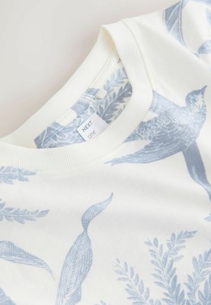 Bomulds-sweatshirt med en blød, cremefarvet base med blå fugle- og bladmotiver. Rund ribbet halsudskæring, mærke synligt inde i kraven.