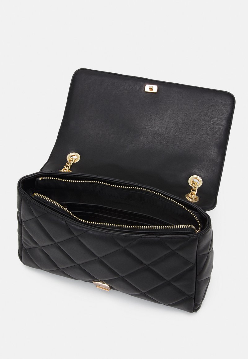 Borsa a tracolla in pelle nera trapuntata con una chiusura dorata, che presenta un ampio interno e scomparti con zipper. Texture liscia con una forma strutturata.