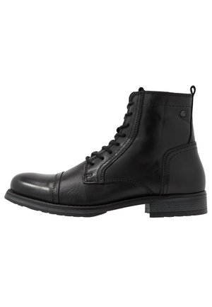 Bottine noire en cuir avec bout renforcé, lacets sur le devant, petit talon empilé et languette à l'arrière.