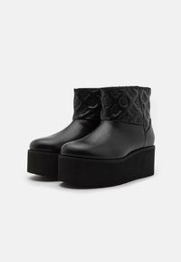 Stivaletti neri con plateau, corpo in pelle liscia, parte superiore trapuntata texture e suola nera solida per un'altezza aggiuntiva.