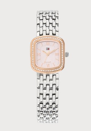Reloj con pulsera de eslabones de metal plateado, bisel rectangular de oro rosa con cristales y esfera rosa claro con números romanos.