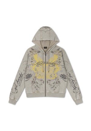 Felpa beige con zip e cappuccio, con design di teschio alato giallo e grafiche nere con scritte sul davanti e sulle maniche.