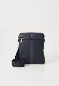 Marine lærcrossbody veske med en fremre glidelås-lomme, justerbar stropp og to vertikale grå striper. Glatt tekstur med sølvfarget detaljer.