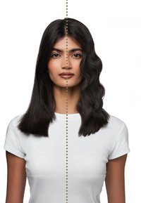 Femme avec de longs cheveux noirs présentant une texture lisse à gauche et une texture ondulée à droite, séparées par une ligne verticale pointillée.