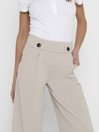 Beige høyt midjer bukser med et bredt ben design, featuring to svarte knapper foran, laget av glatt stoff med en myk tekstur.