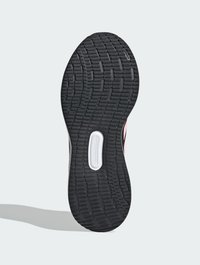 Semelle en caoutchouc noir avec un motif de crampons texturé, dotée d'une semelle intermédiaire blanche et d'accents roses sur le côté, conçue pour la traction et la durabilité.