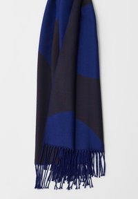 Sciarpa blu e blu navy in tessuto morbido, caratterizzata da un motivo geometrico con bordi frangiati, che aggiunge texture e profondità.