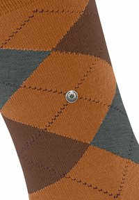 Calzino argyle marrone e grigio con tessuto testurizzato, caratterizzato da forme a diamante a contrasto e un piccolo dettaglio con logo argentato.