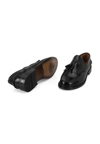 Zwarte leren loafers met een gladde afwerking, gedetailleerde franjes, een gewatteerde binnenzool en een rubberen loopzool, met duidelijke stiksels overal.