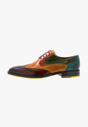 Zapato brogue de cuero para hombre con puntera alada en marrón, beige, verde y azul, con detalles perforados y acentos de suela amarilla.