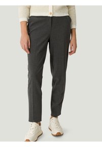 Dopasowane szare spodnie wykonane z teksturowanej tkaniny, o wąskim kroju i prostych nogawkach, zestawione z białymi trampkami.