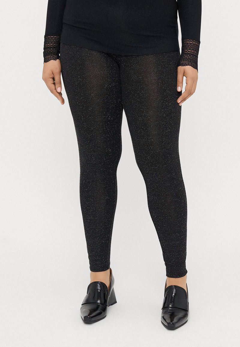 Juodos leggingai, pagaminti iš struktūrinio audinio su subtiliais blizgančiais akcentais. Derinami su blizgiais juodais aukštakulniais šlepetėmis.