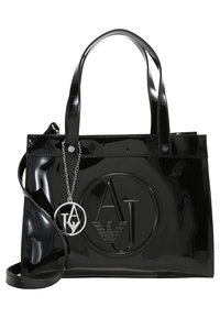 Svart lackläder handväska med rektangulär form, präglad logotyp på framsidan, dubbla handtag och en avtagbar kedjeprydnad.