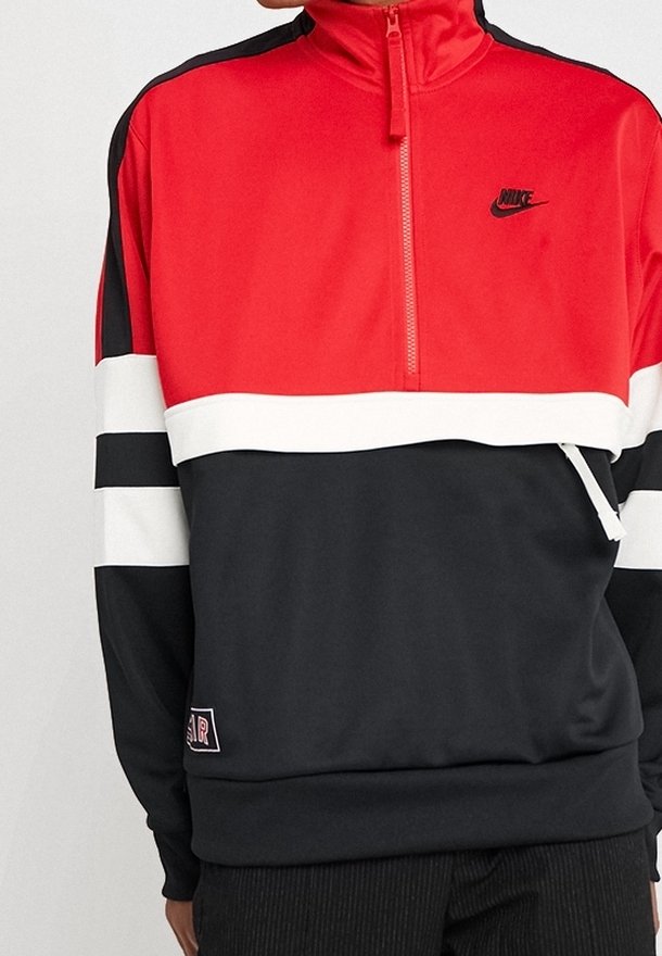 Röd, svart och vit Nike zip-up sweatshirt med hög krage, kontrasterande horisontella ränder och en liten logotyp på bröstet. Mjuk textur.