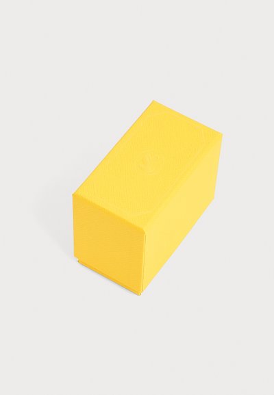Boîte rectangulaire jaune vif avec une texture subtile en relief et un motif circulaire clair sur le dessus, présentée sur un fond clair uni.