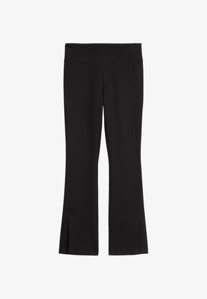 Svart vide leggings laget av elastisk stoff, med bredt midjebånd og subtile sidesplitter i kanten for ekstra detaljer.