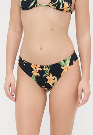 Svart bikinitruse med blomstermønster som har oransje blomster og grønne blader. Glatt stoff, lav livvidde design og minimal dekning.