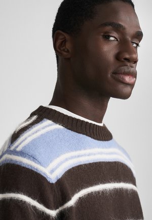 Sweater às riscas castanhas e azul claro com decote canelado, apresentando uma textura peluda e detalhes brancos. Projetado com um corte relaxado.