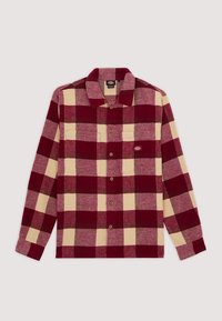 Chemise à manches longues à carreaux rouges et beiges, boutonnée, avec col et petit logo brodé sur la poche poitrine gauche.