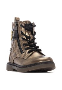 Botín metálico de bronce con textura acolchada, parte delantera negra con cordones y cremallera lateral, que presenta un acento decorativo amarillo y negro.