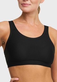 Svart sportbh i texturerad tyg med rundad halsringning och breda axelband för stöd. Enkelt design utan synliga knäppningar.