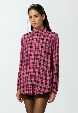 Chemise à manches longues à carreaux rose et noir avec fermeture à boutons, poche poitrine et détails de logo sur le côté gauche. Tissu lisse, coupe cintrée.