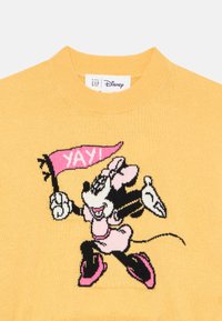 Rumena pletena jopica z črno in roza grafiko Minnie Mouse, ki drži roza zastavo z napisom "YAY!", okrogli ovratnik, mehak otip.