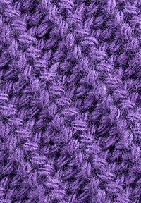 Close-up of a textured purple knitted fabric with a detailed pattern of interwoven yarn loops.
