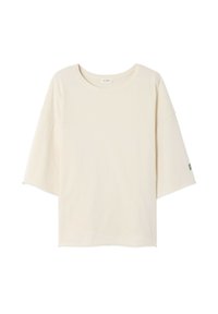 Koszulka w kolorze kremowym z okrągłym dekoltem, krótkimi rękawami typu dolman i małym zielonym logo na lewym rękawie. Miękka, lekka tkanina.